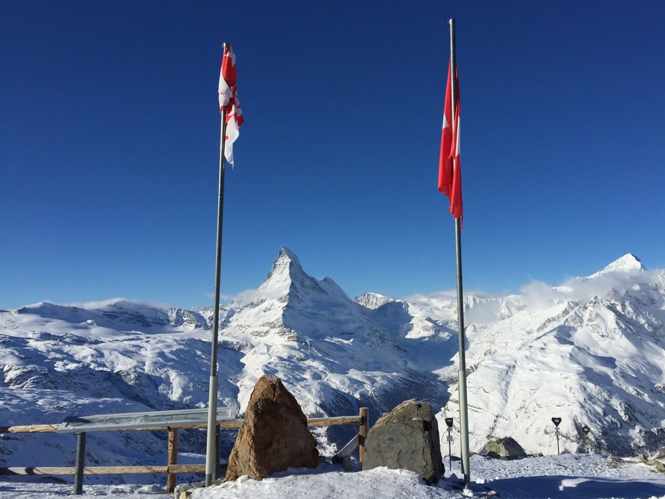 Matterhorn im Schnee, im Vordergrund zwei Fahnen.