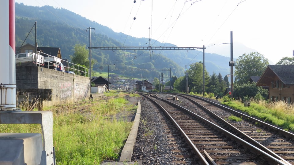 Bahnschienen, in der Ferne der Bahnhof Leissigen.