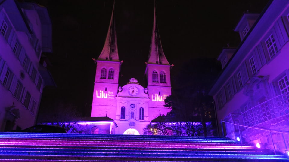 Die Hofkirche Luzern in violettem Licht.
