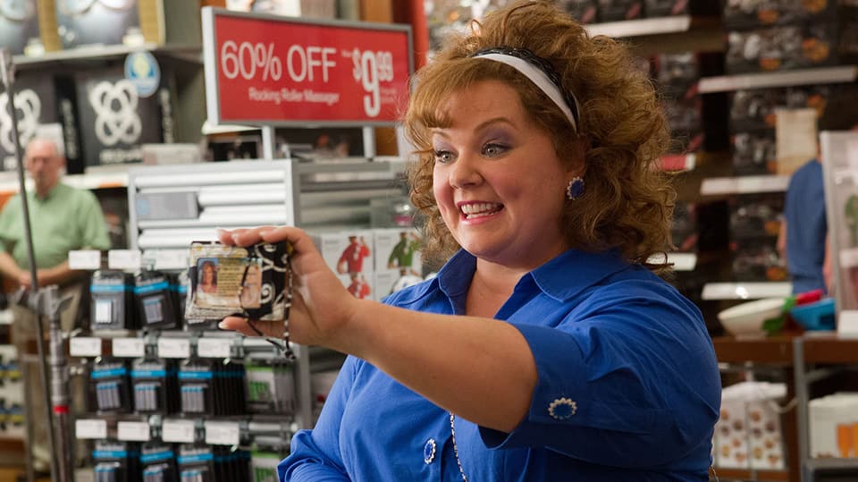 Melissa McCarthy zeigt in einem Laden ihre ID.