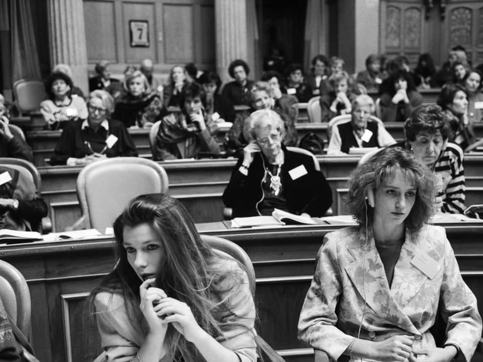 Frauen sitzen im Bundeshaus und verfolgen die Debatte.