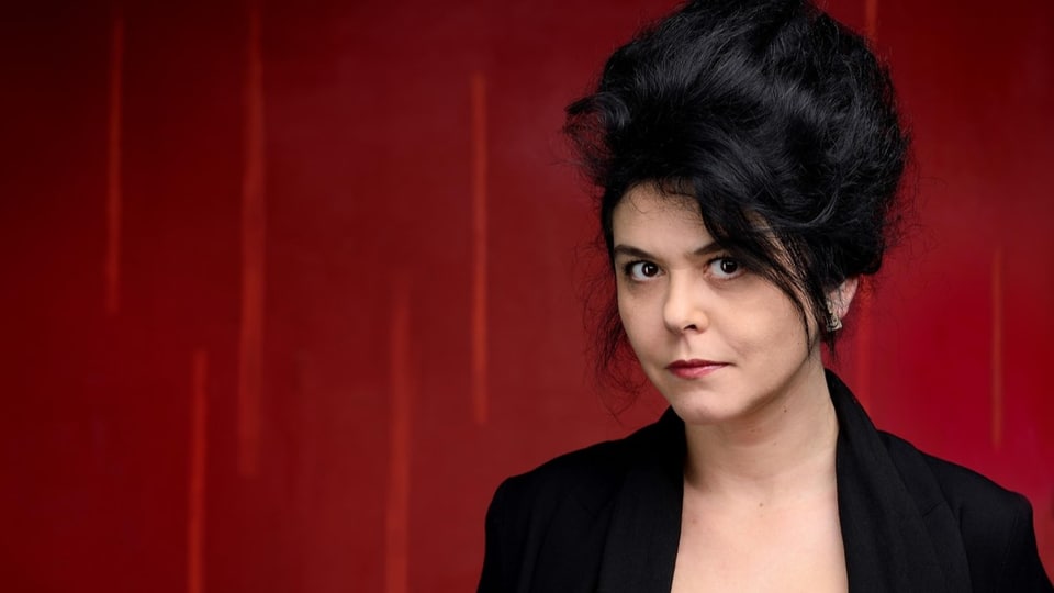 Chloé Delaume vor einem roten Vorhang.
