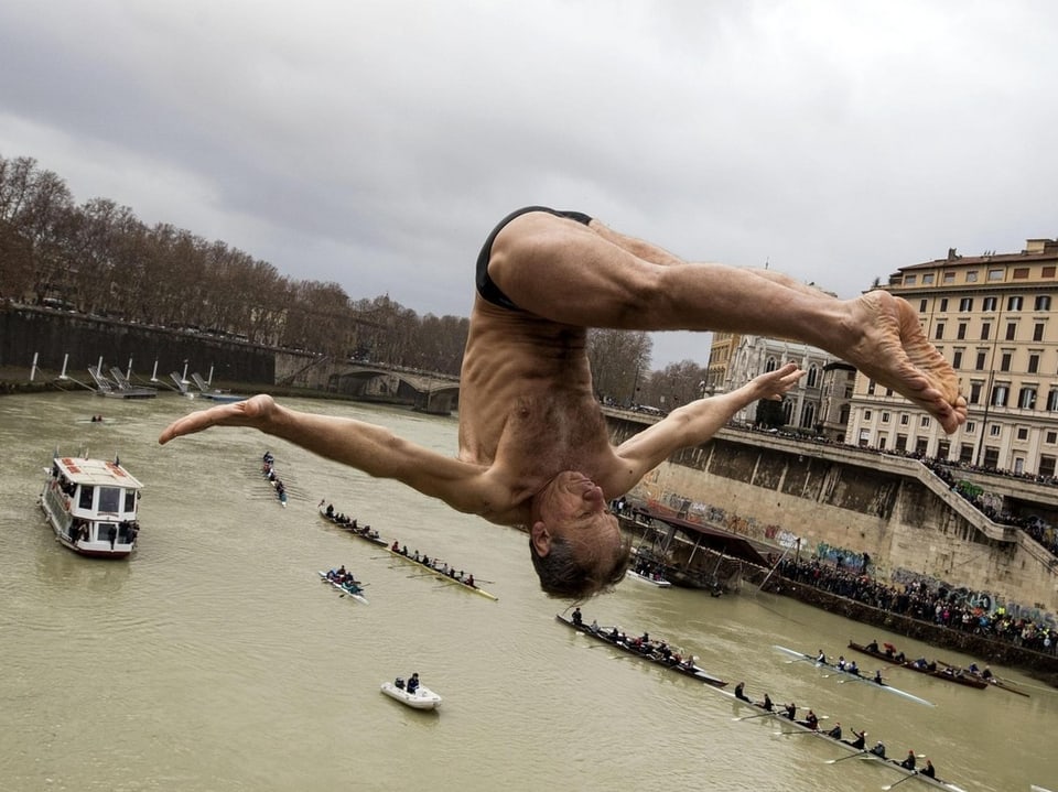 Ein Mann macht eine Sprungfigur in den Tiber