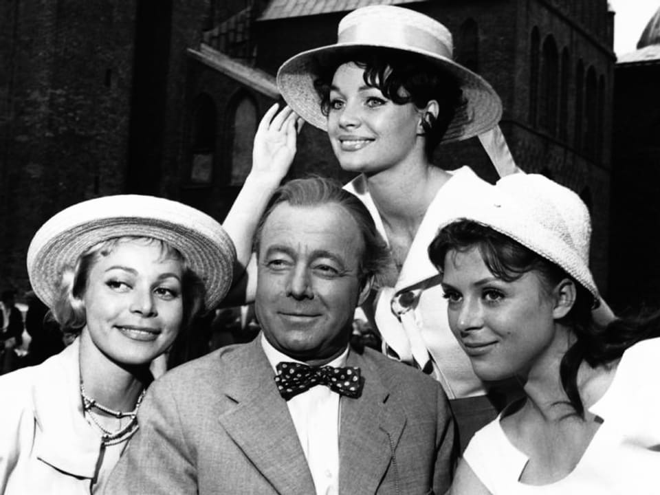 Ein Schauspieler ist umgeben von drei Frauen.