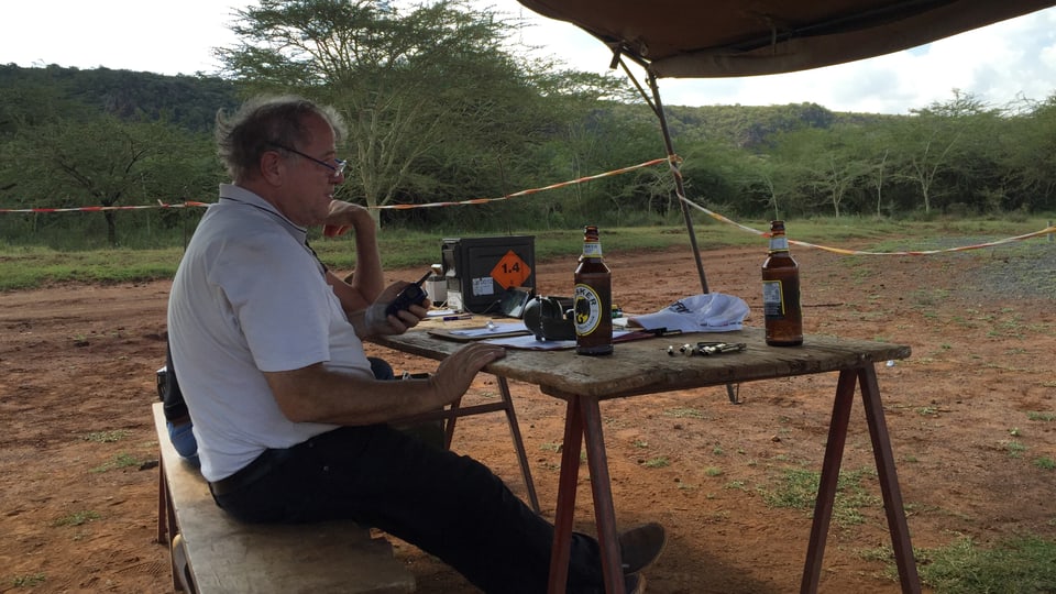 Max Hellbach im Schützenzelt mit einer Flasche kenianischem Tusker-Bier. 