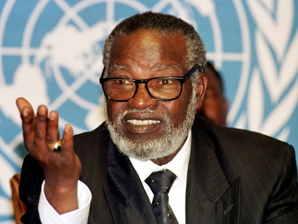 Ein afrikanischer Mann mit weissem Bart vor dem UNO-Logo.