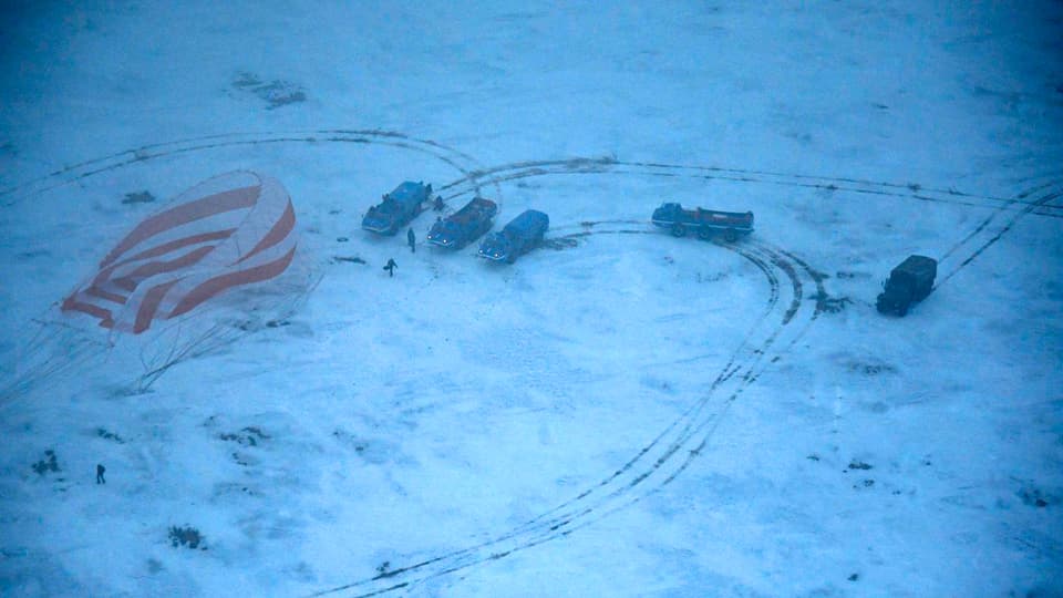 Blick aius einem Helikopter auf den verschneiten Landeplatz der Sojus-Kapsel.