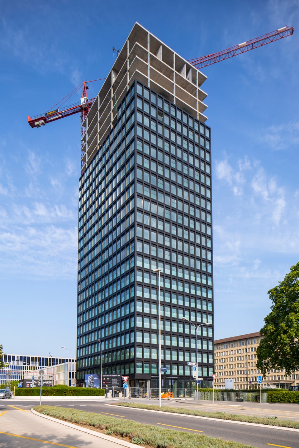 Ein unfertig gebautes Hochhaus, dahinter ein Kran