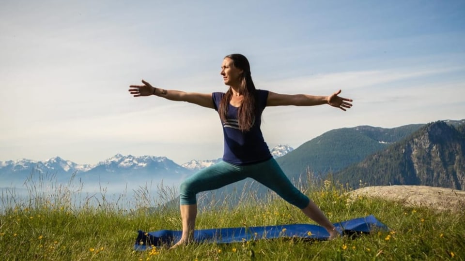 Die Yoga-Lehrerin Tiziana Dionisio macht vor einem Bergpanorama eine Yoga-Pose.