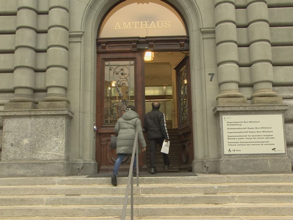 Ein Mann und eine Frau betreten das Amtshaus Bern.