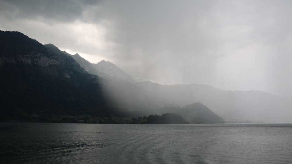 Ein Regenschauer zieht auf - graue Regenwolken über dem Thunersee.