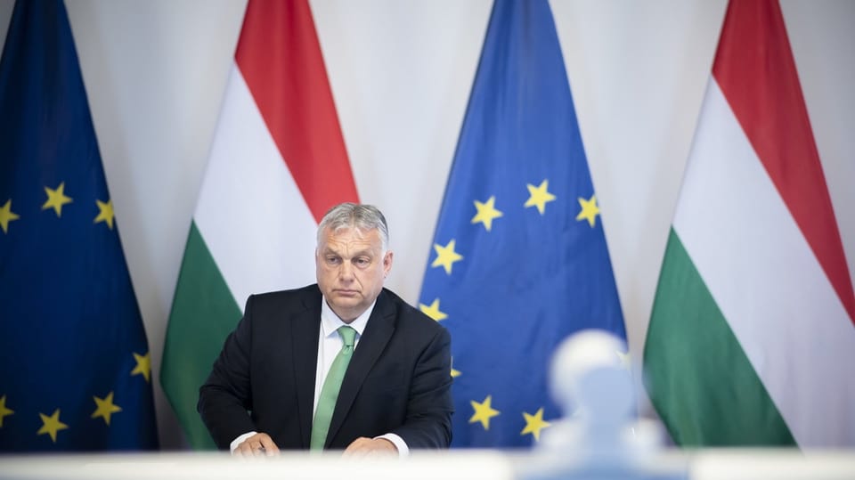 Ungarns Premierminister Viktor Orban, im Hintergrund die EU-Flagge und Ungarns Flagge