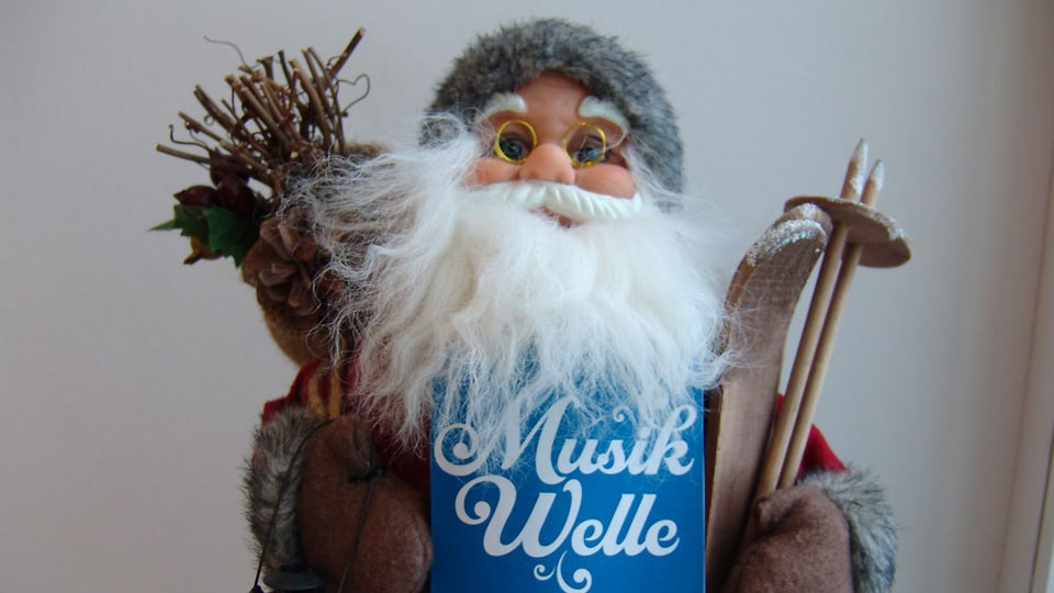 Samichlaus-Figur mit Holz, Skiern und dem Logo SRF Musikwelle.