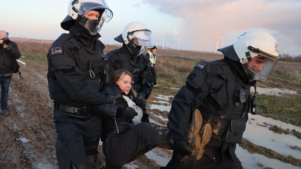 Polizisten tragen Greta Thunberg weg.