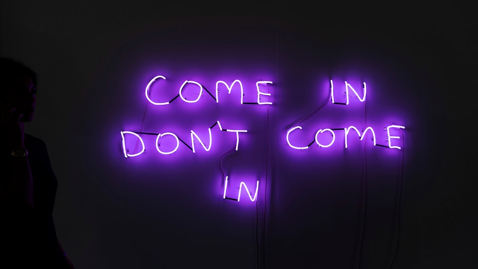 Die Worte «come in, don't come in» sind an der Art Basel mit Leuchtbuchstaben an die Wand geschrieben.