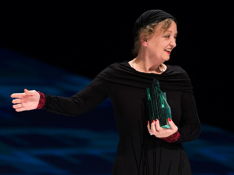 Sibylle Brunner, in schwarzem Kleid, hält den Quartz-Preis in der Hand.