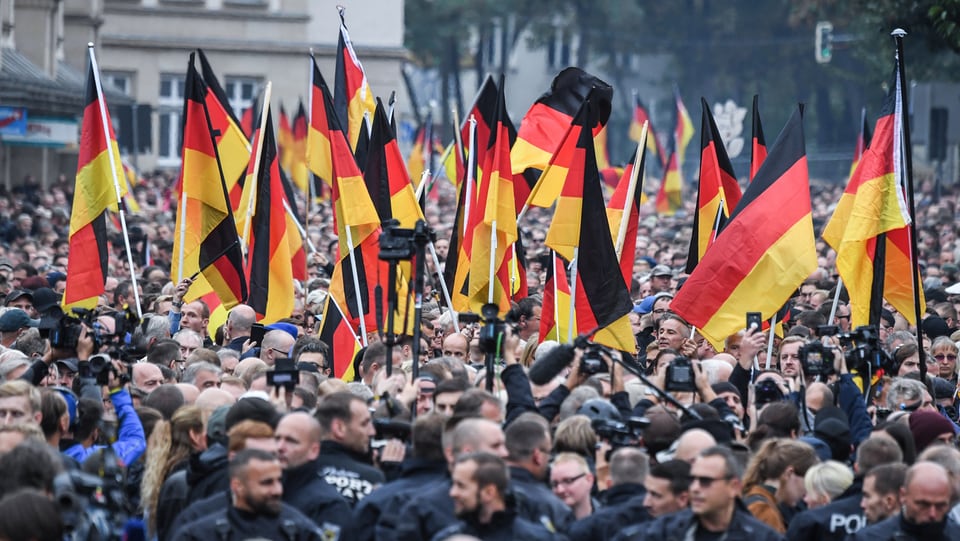 Eine Demonstration mit vielen Menschen, Polizei und vielen Deutschland-Fahnen.