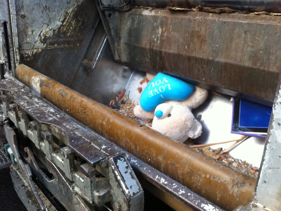 Ein Plüschbär im Abfallwagen.