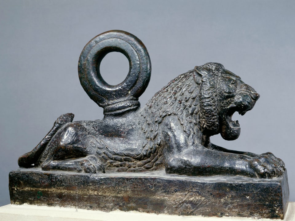 Löwenfigur aus Bronze, an deren Rücken ein Ring befestigt ist.