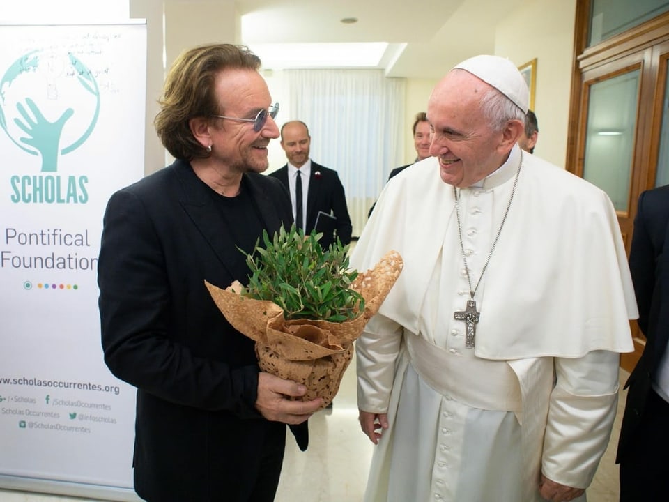 Bono mit Blumenstrauss neben Papst Franziskus