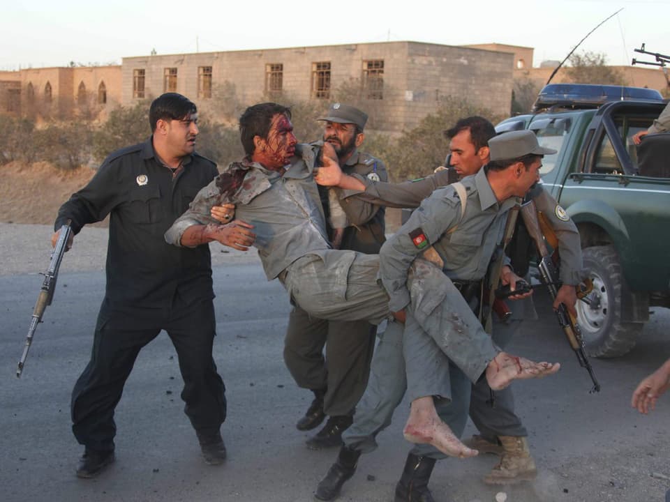 Afghanische Soldaten und Polizisten bergen einen Verletzten.