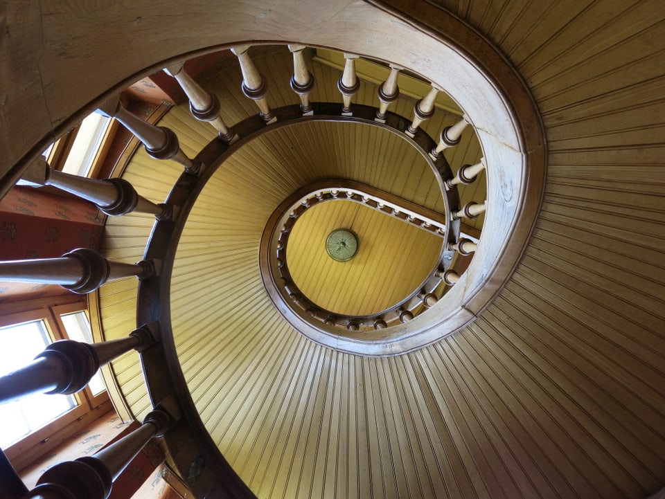 Blick in das Treppenhaus der Villa. Treppe windet sich nach oben.