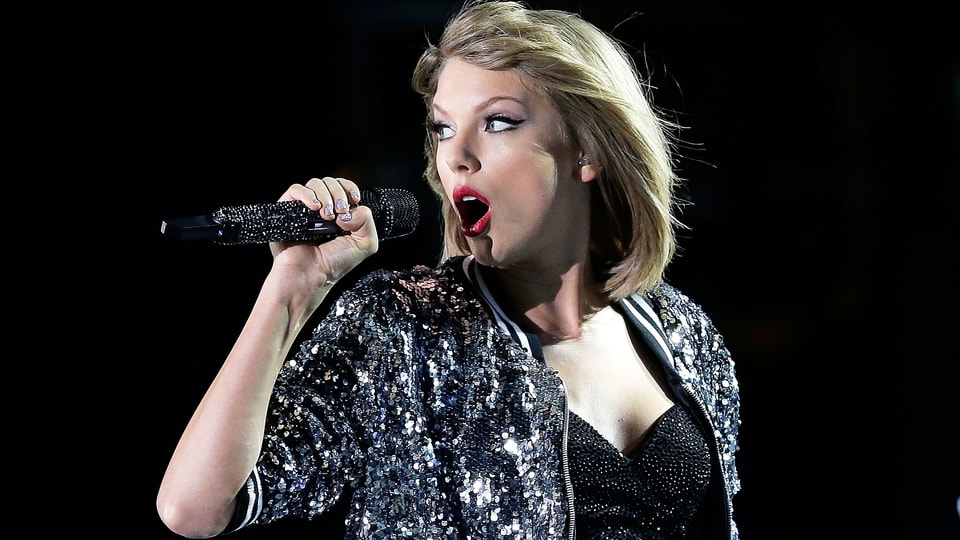 Taylor Swift singt ins Mikrofon.