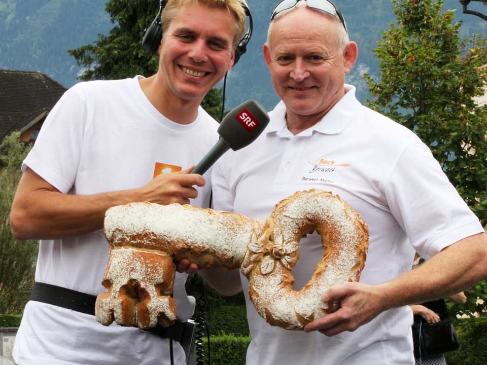Zwei Männer präsentieren einen Schlüssle aus Brot.