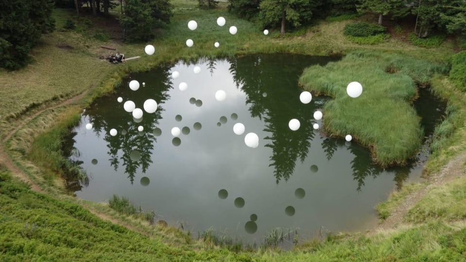 Kunstinstallation mit weissen Kugeln über einem See