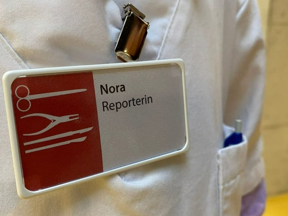 Nora trägt ein rotes Namensschild. Darauf steht «Reporterin»