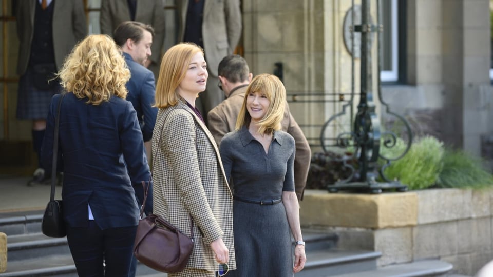 Zwei Frauen sprechen miteinander vor einer Kirche.