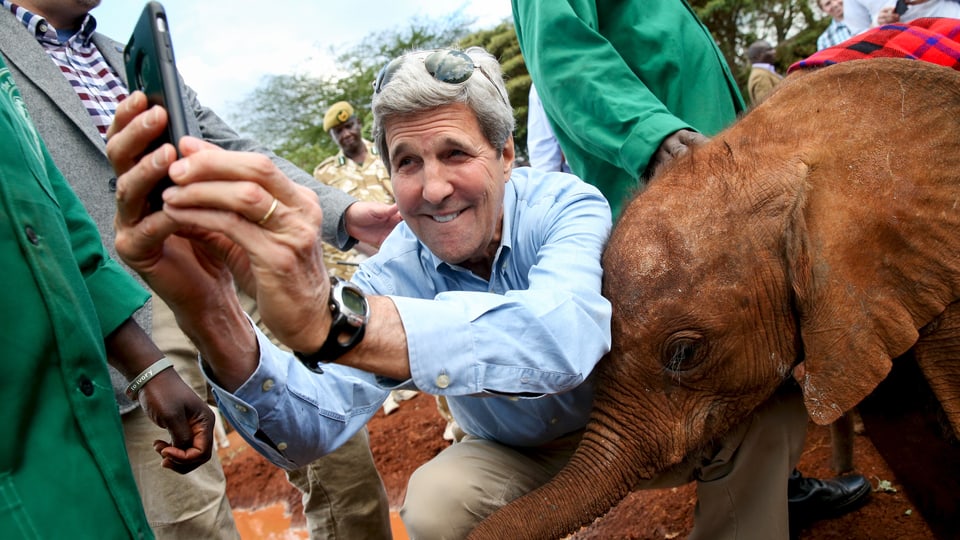 John Kerry macht ein Selfie mit einem Elefantenjungen