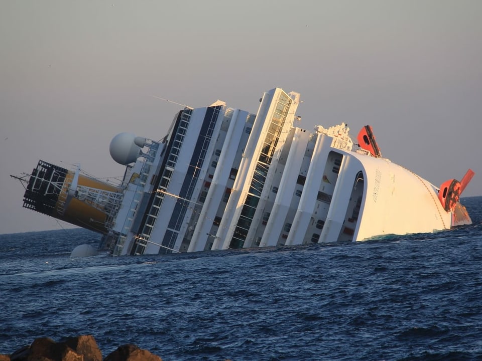 Die Costa Concordia, zur Seite geneigt und halb versunken, vor Giglio.