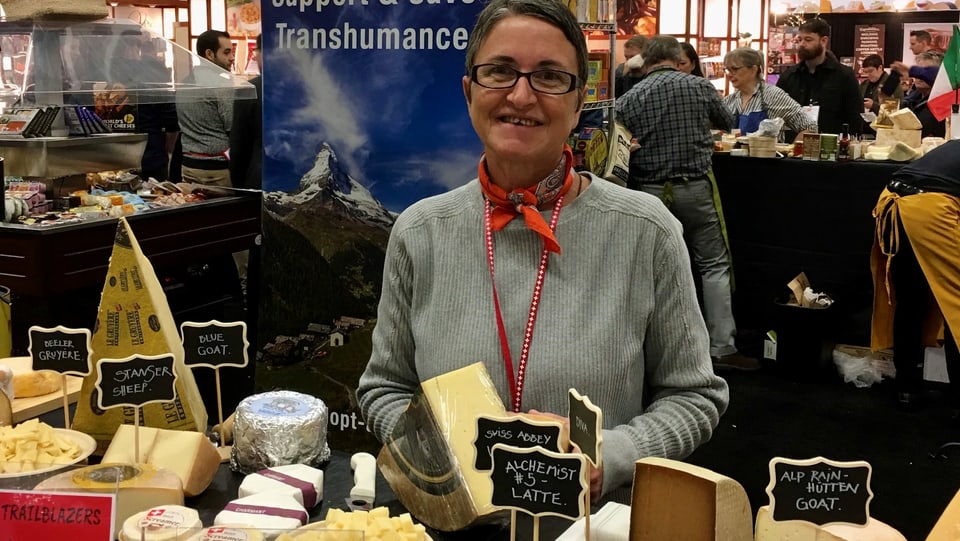 Käseimporteurin Caroline Hostettler steht hinter einem Käsestand an einer Foodmesse in den USA.