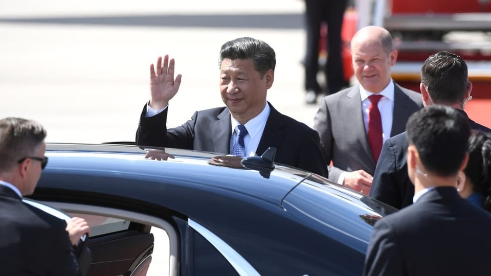 Xi winkt, bevor er i nein Auto steigt, hinter ihm steht Scholz.