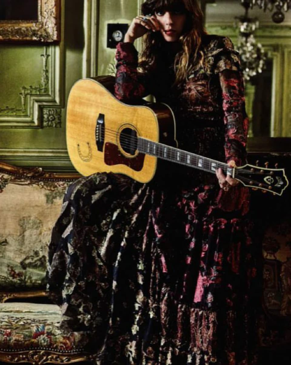Lou mit Gitarre und wallendem Kleid