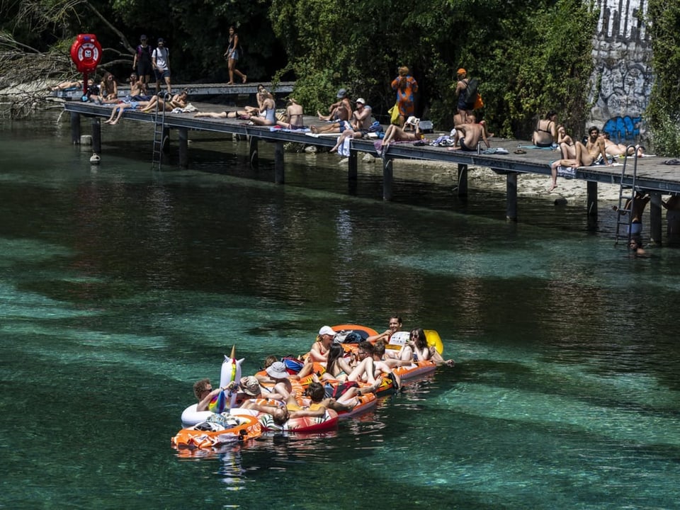 Auf der Rhone in Genf geniessen Menschen am Samstag den Sommer im Gummiboot.