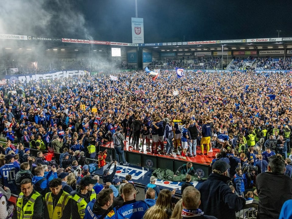Die Spieler von Holstein Kiel feiern mit ihren Fans den Aufstieg.