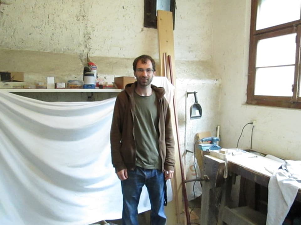 Freundlich lächelnder Mann in einer sauber aufgeräumten Werkstatt.