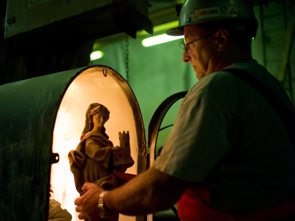 Ein Bauarbeiter nimmt eine weibliche Statue aus ihrem Schrein.