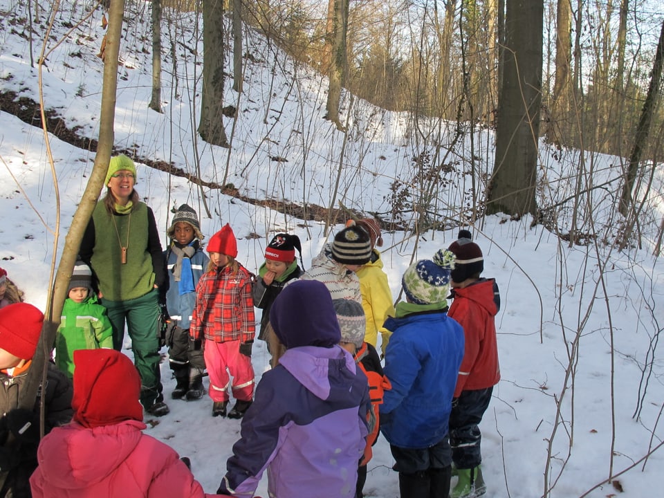 Kindergartenkinder stehen im Kreis und singen ein Lied.