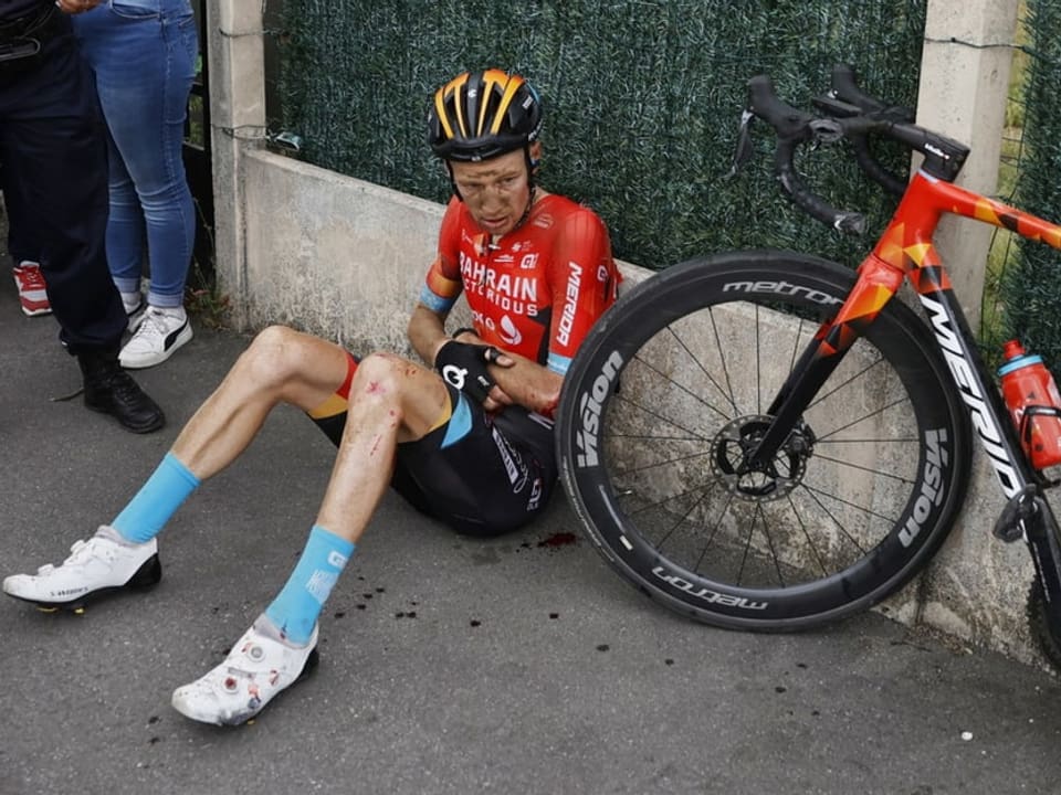 Jack Haig sitzt am Boden neben seinem Velo