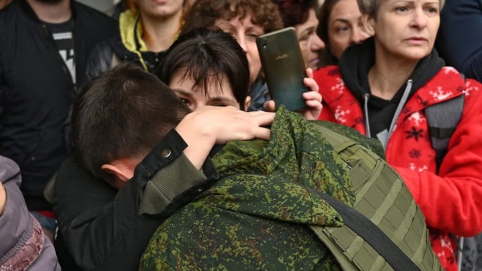 Eine Frau verabschiedet einen russischen Soldaten, der in den Ukraine-Krieg ziehen muss.