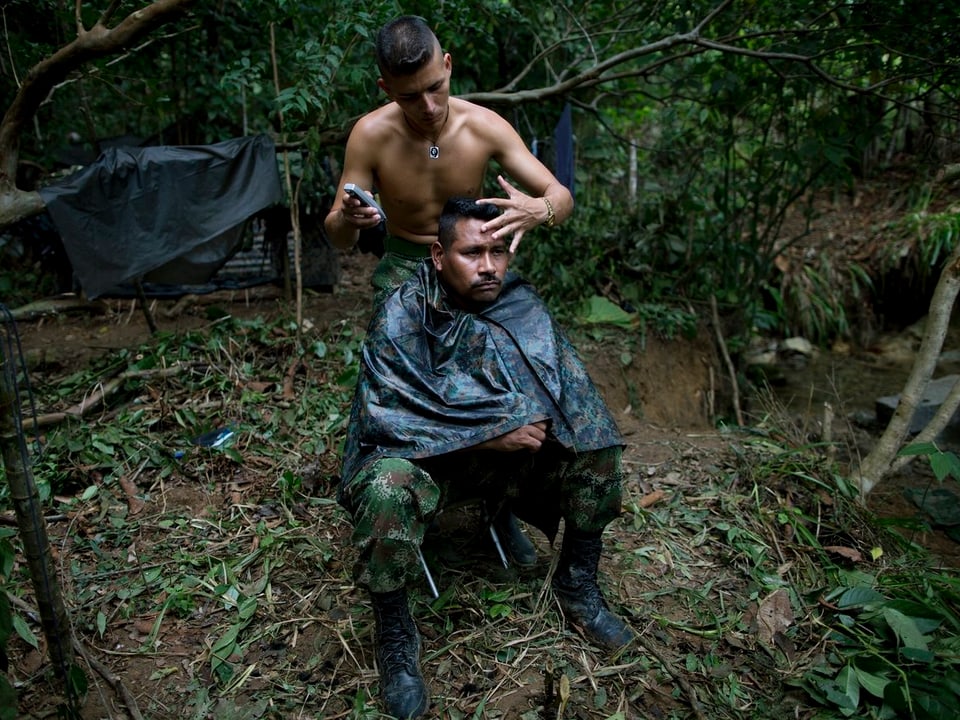 Farc-Kämpfer rasiert seinem Waffenbruder den Kopf.