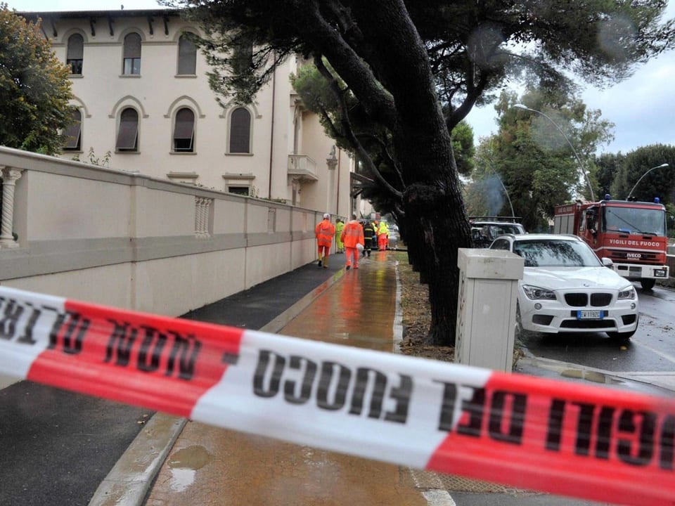 Absperrband vor überfluteter Strasse in Livorno, im Hintergrund das Haus, in dem fünf Menschen umkamen
