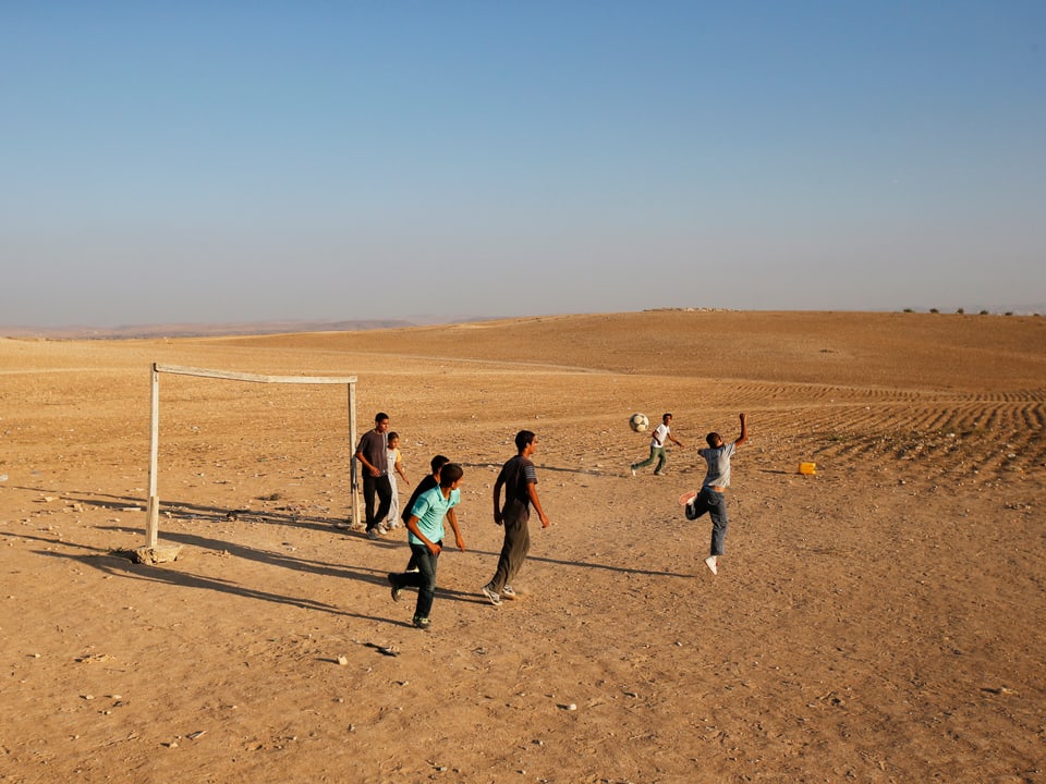 Kinder spielen in der Negev-Wüste Fussball. 