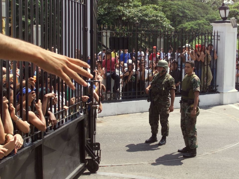 Anhänger drängen sich am Gitter vor dem Präsidentenpalast