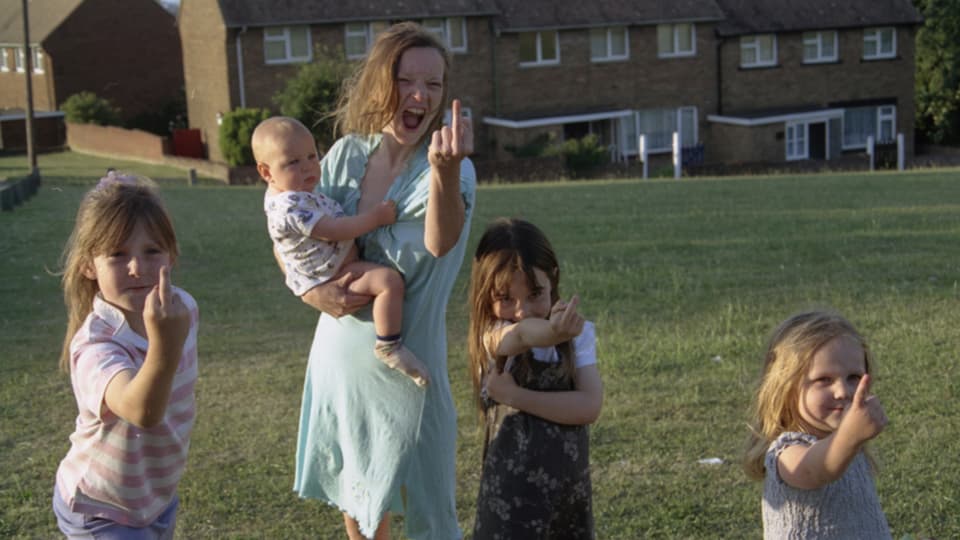Eine Frau und drei Kinder zeigen den Mittelfinger.