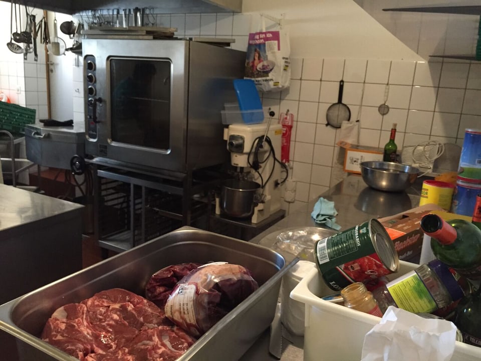 Blick in die Küche mit Utensilien und Fleisch.