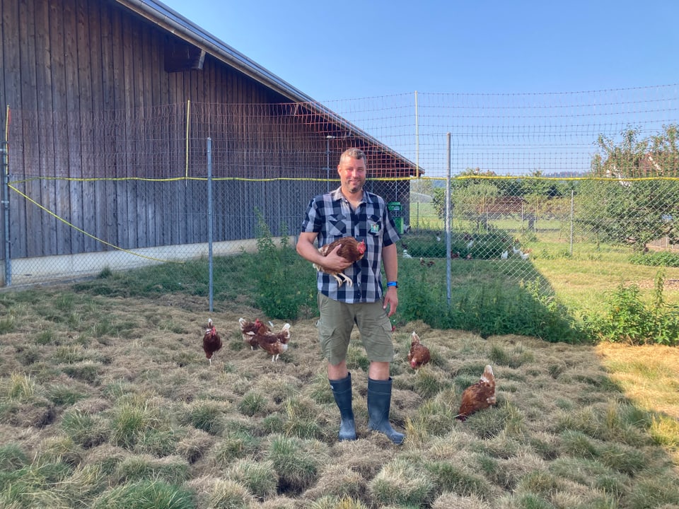 Landwirt mit Huhn in der Hand